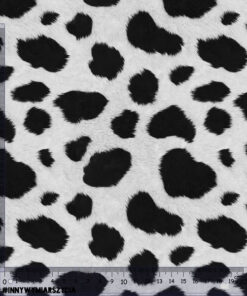 Black and white cow print fabric with irregular spots and a visible measuring scale along the left and bottom edges, marked in centimeters.